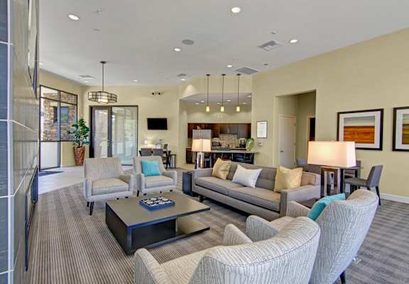 A living room with a grey couch, a coffee table, and a lamp.