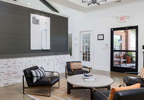 a living room with black leather chairs and a coffee table