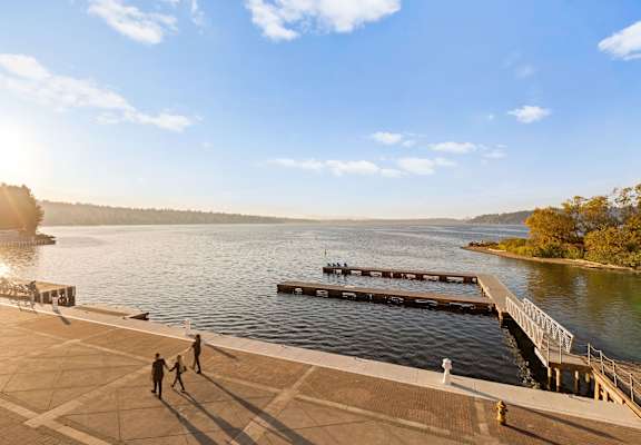 people walking on a dock overlooking a river