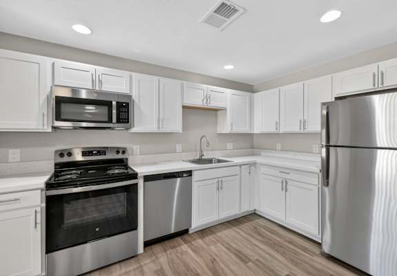 A kitchen with white cabinets and stainless steel appliances.