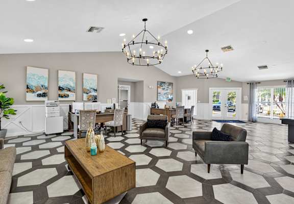 A spacious living room with a patterned floor and a large chandelier. at Cascades at Clear Lake Apartments, Florida, 33908