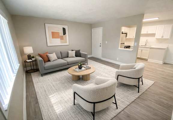 A living room with a grey couch, two armchairs and a coffee table. at Willow Brooke Apartments, Tampa, FL, 33613