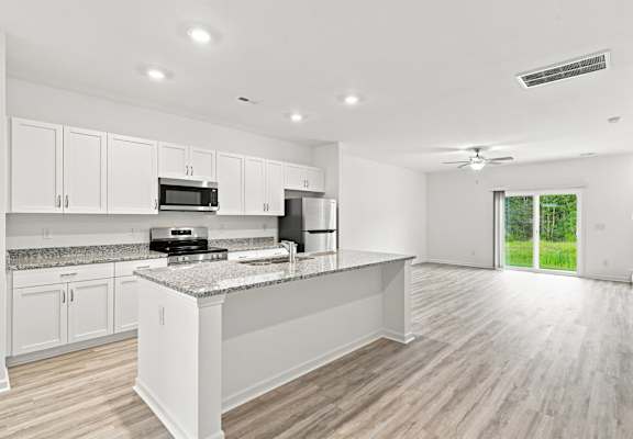 A modern kitchen with white cabinets and a central island.