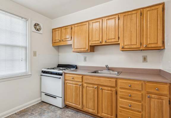 a kitchen with wooden cabinets and a stove and a sink