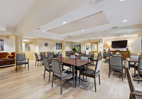 a large room with a large table and chairs and a flat screen tv on the wall