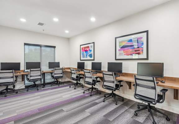 a conference room with desks and chairs and paintings on the wall