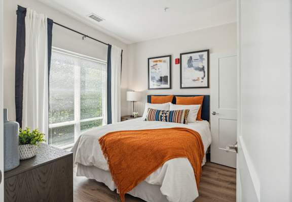 a bedroom with a bed and a large window