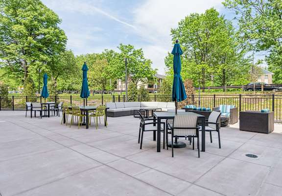 a patio with tables and chairs and umbrellas