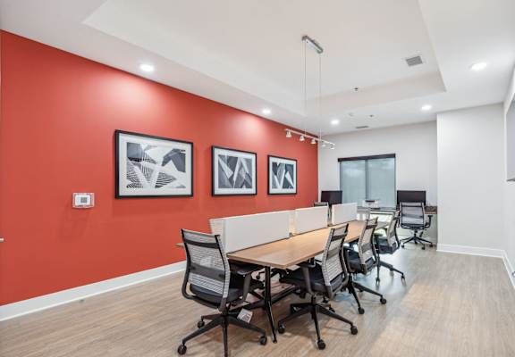 a conference room with a long table and chairs and a red accent wall