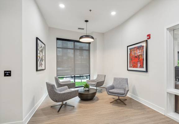 a living room with two chairs and a table and a window