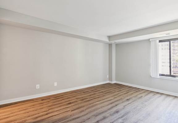 an empty room with wood floors and a window