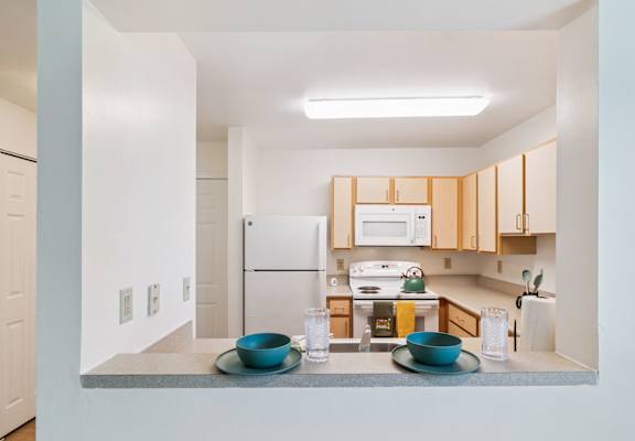 A kitchen with a white fridge and wooden cabinets.