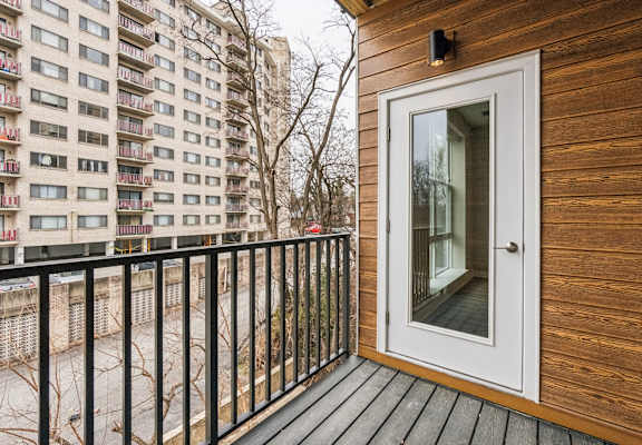 A balcony with a white door and a black railing.
