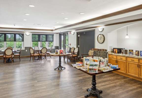 A room with a table and chairs and a clock on the wall.