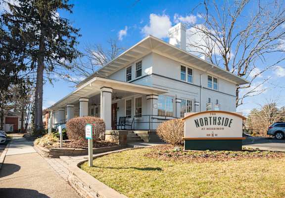 A white building with a sign that says Northside in front of it.