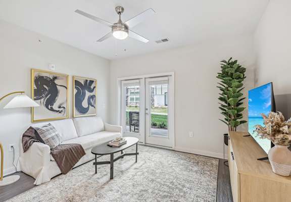 a living room with a white couch and a ceiling fan