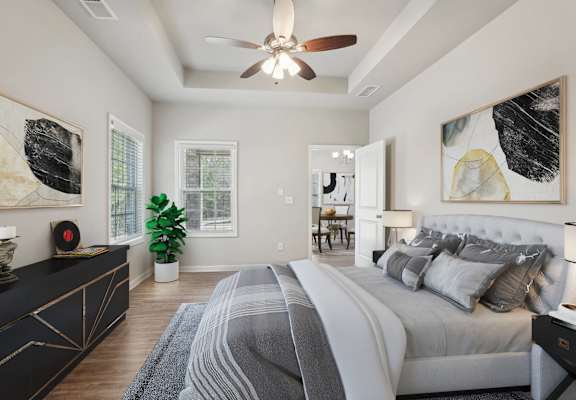 A bedroom with a large bed and a ceiling fan.