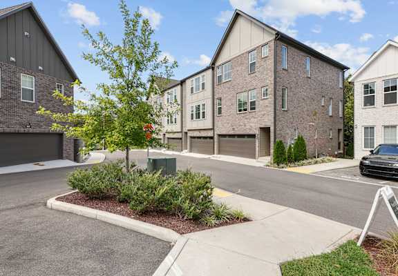 A tree in a planter is the only thing separating the street from the front yards of two houses.