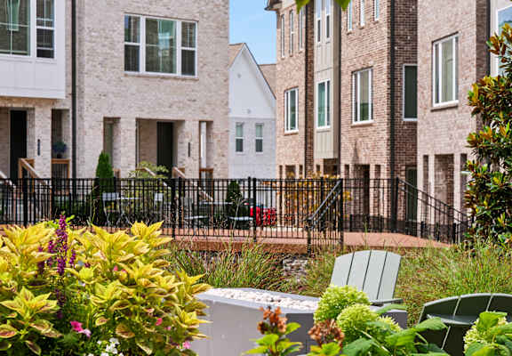 A row of houses with a black fence in front.