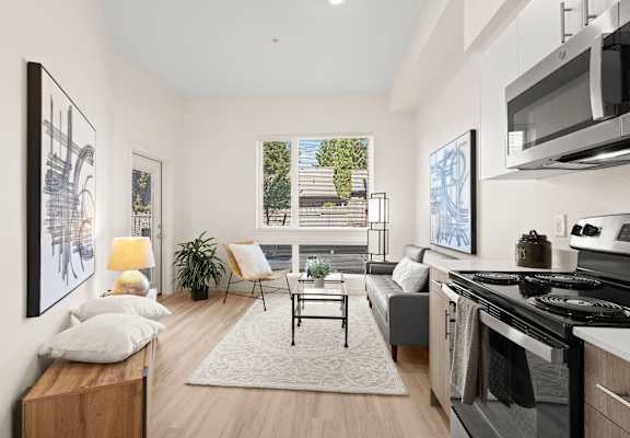 a living room with a kitchen and a large window at The Duo, University Place Washington