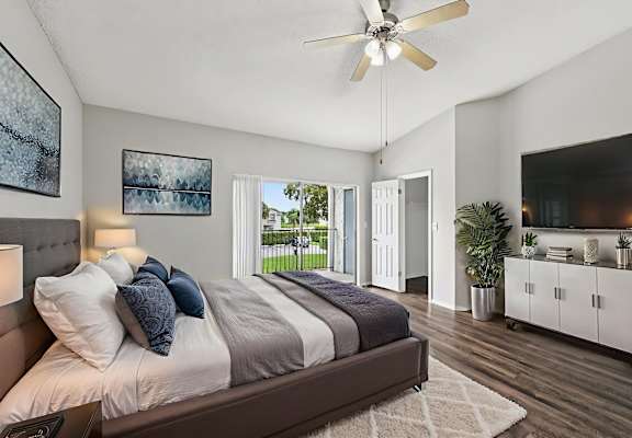A bedroom with a large bed and a ceiling fan.