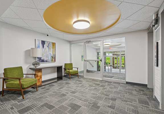 A conference room with a yellow ceiling light and a painting on the wall.