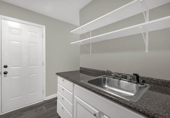A kitchen with a sink and a door.