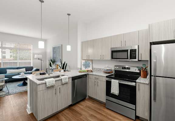 A modern kitchen with stainless steel appliances and wooden cabinets.