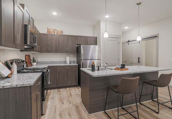 A modern kitchen with a large island and bar stools.