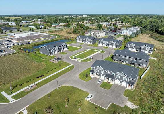 A bird's eye view of a residential area with houses and a parking lot.