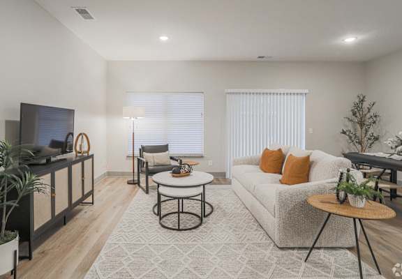 A living room with a white couch, a television, and a coffee table.