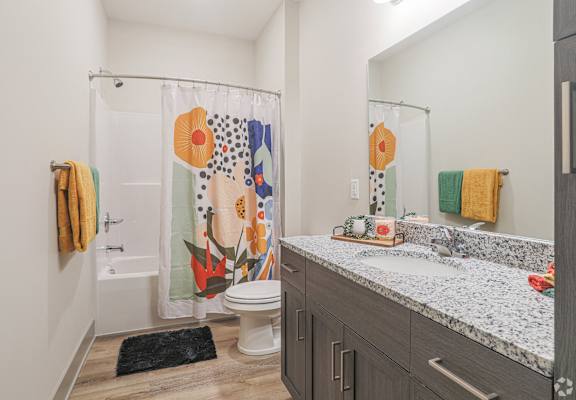 A bathroom with a toilet, sink, and shower curtain.