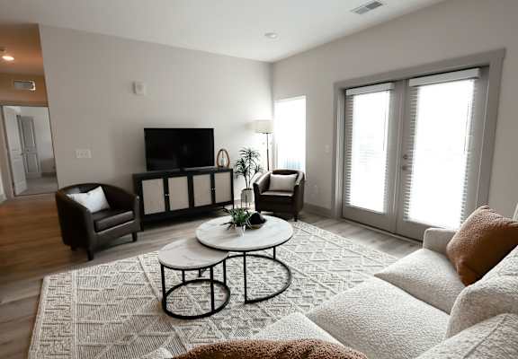 A living room with a white couch and a black television.