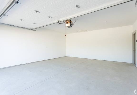 A large, empty room with white walls and a concrete floor.