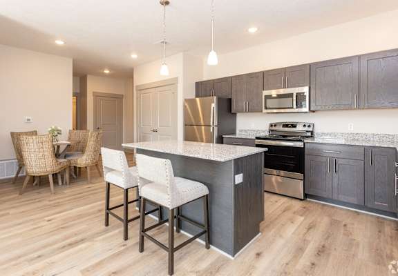 A kitchen with a bar area and a dining table.