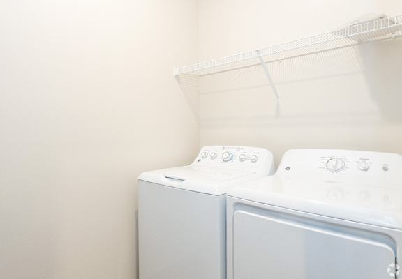 A white washing machine sits in a laundry room.