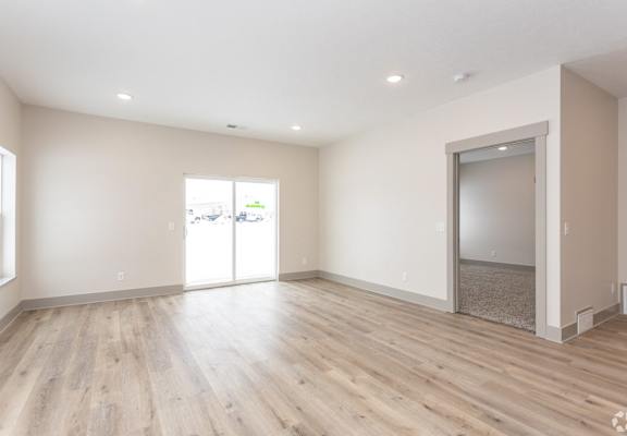A room with wooden floors and a sliding glass door.