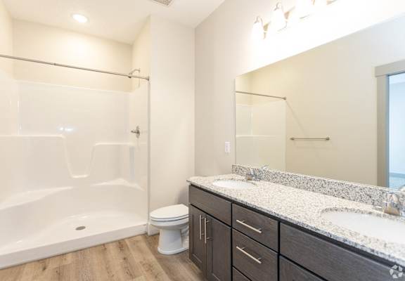 A bathroom with a white tub, sink, and toilet.