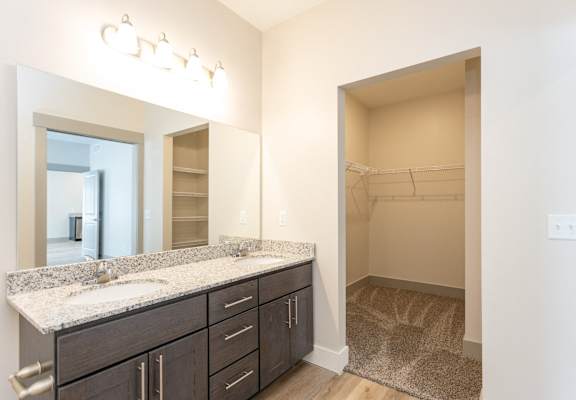 A bathroom with a sink, mirror, and cabinets.