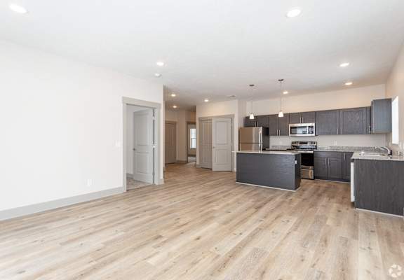 A spacious kitchen with wooden floors and modern appliances.