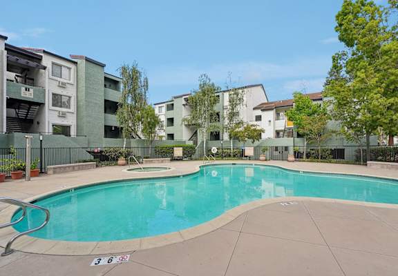 A swimming pool surrounded by apartment buildings.