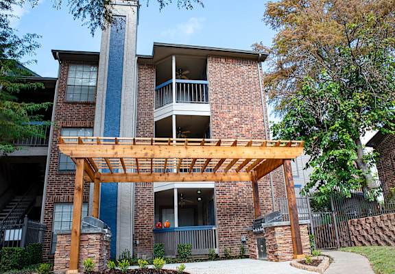 the view of a brick apartment building with a wooden porch at Infinity on the Mark, Dallas, Texas