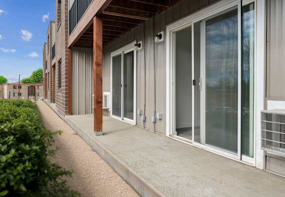A building with a concrete walkway and glass doors.