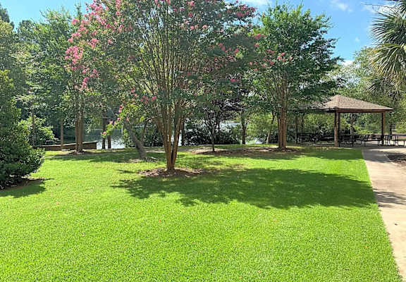 A gazebo sits in the middle of a grassy area.