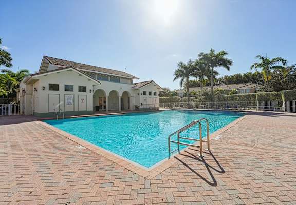 A sunny day at the pool with a building in the background.