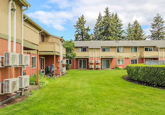 A grassy courtyard is surrounded by apartment buildings.