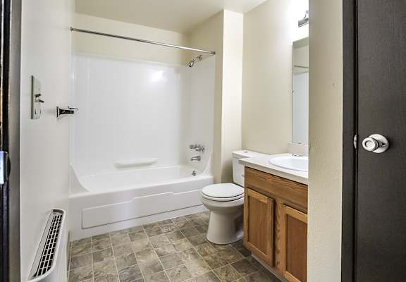 A bathroom with a white tub, toilet, and sink.