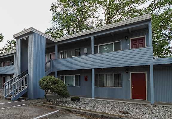 A blue building with a red door and windows.