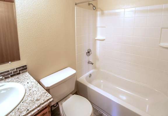 A white toilet sits next to a sink in a small bathroom.