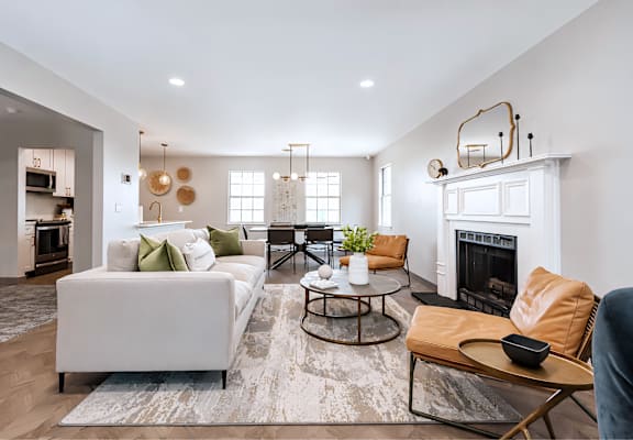 A modern living room with a white sofa, a coffee table, and a fireplace.